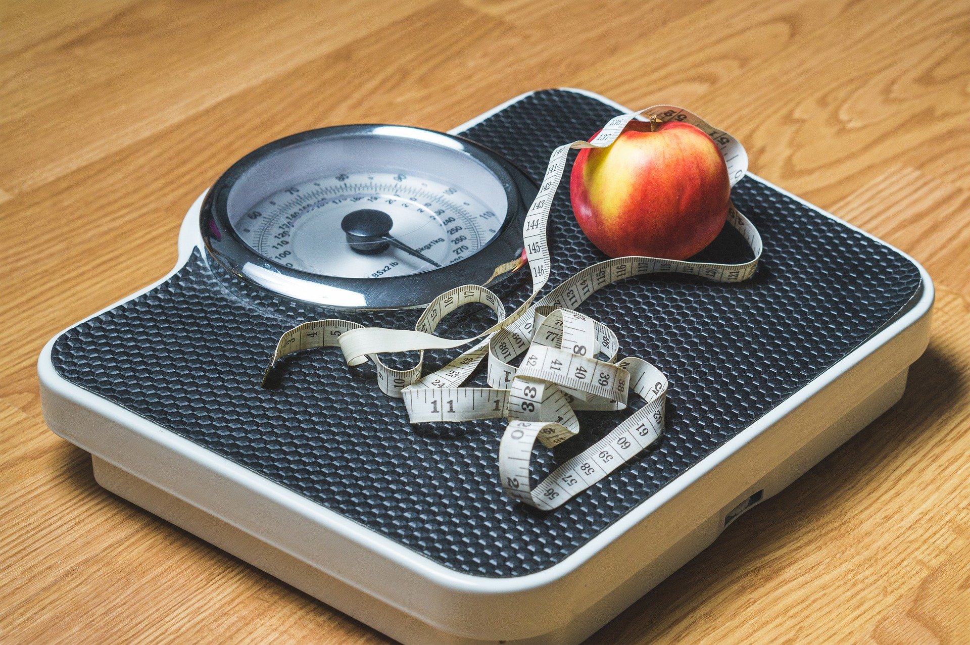 Scales with a measuring tape and an apple on top